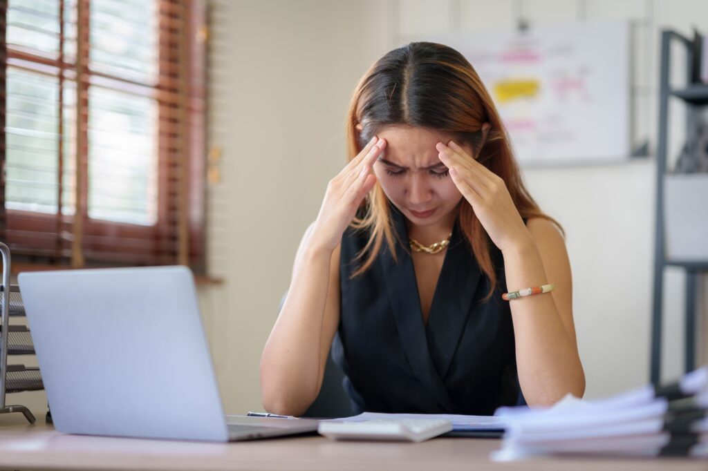 Asian businesswoman feeling stressed at work when faced with difficult tasks and unresolved problems