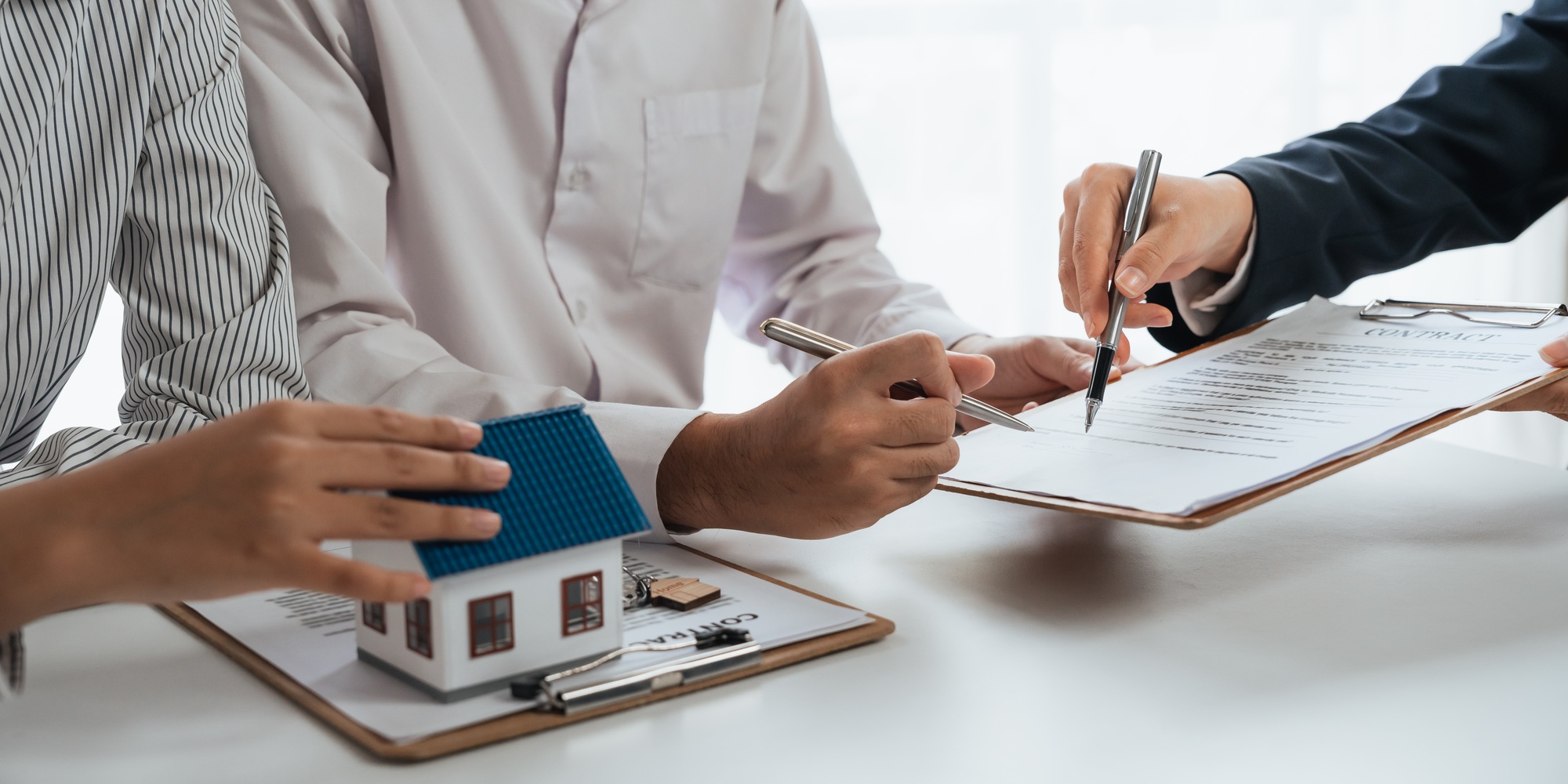 Happy couple signing a contract with real estate agent. renters tenants sign mortgage loan