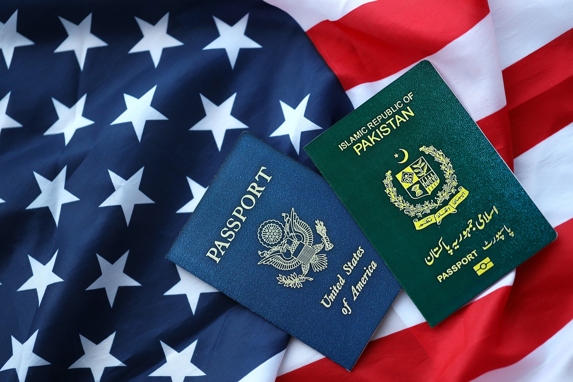 Passport of Pakistan with US Passport on United States of America folded flag