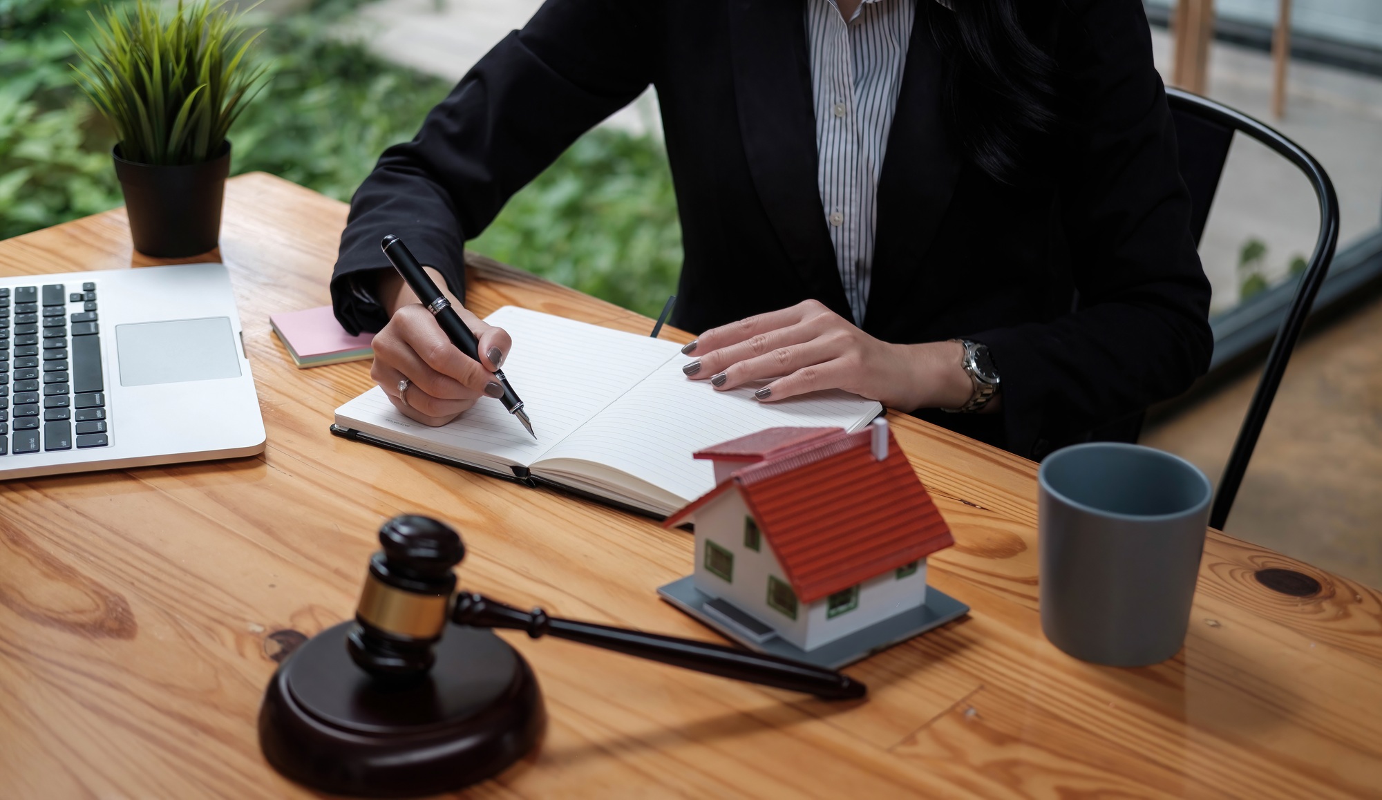 Real Estate Law concept. Gavel on sounding block in hand's female judge at a courtroom, working for