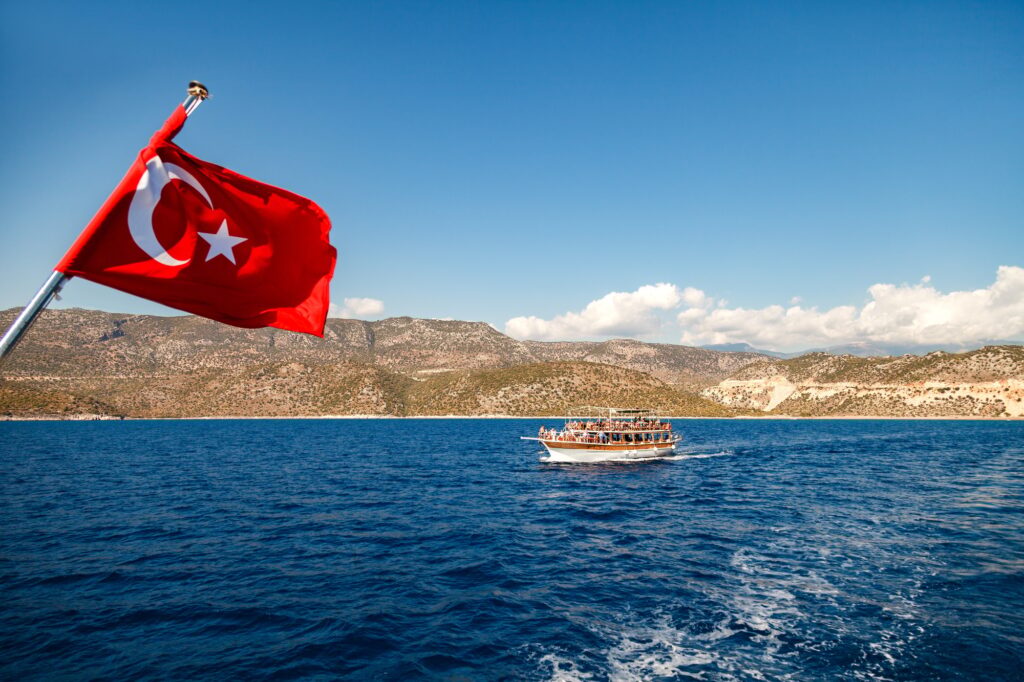 Yacht under the Turkish flag in the Mediterranean. Beautiful view of Kemer mountains